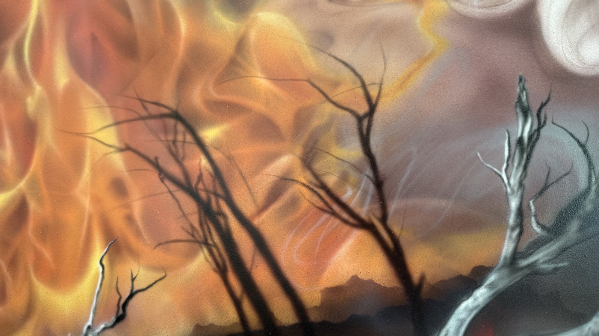 Airbrushed bushfire burning behind bare burnt trees